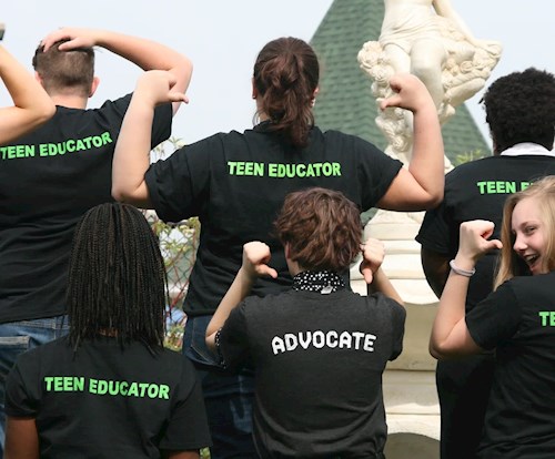 Teens showing messages on the back of their t-shirt